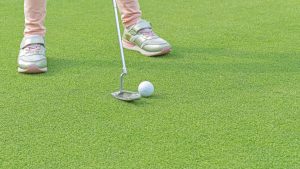 Giovane giocatrice di golf sul green