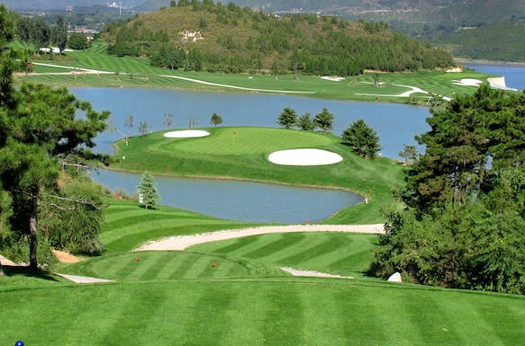 il green di un campo da golf con percorso collinare visto dall'alto